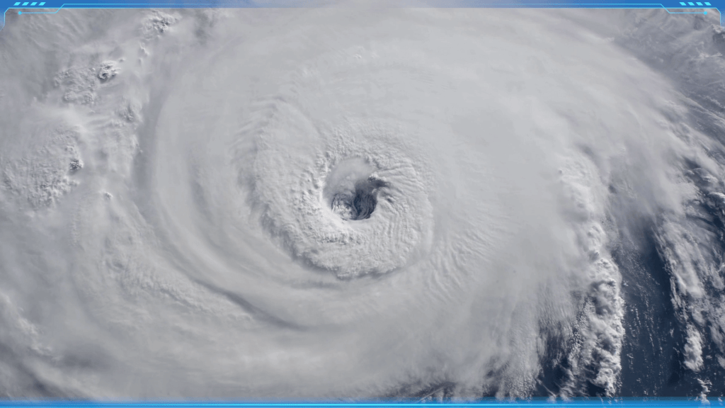 A powerful rotating storm system viewed from space, showing the eye and swirling clouds of a Hurricane.