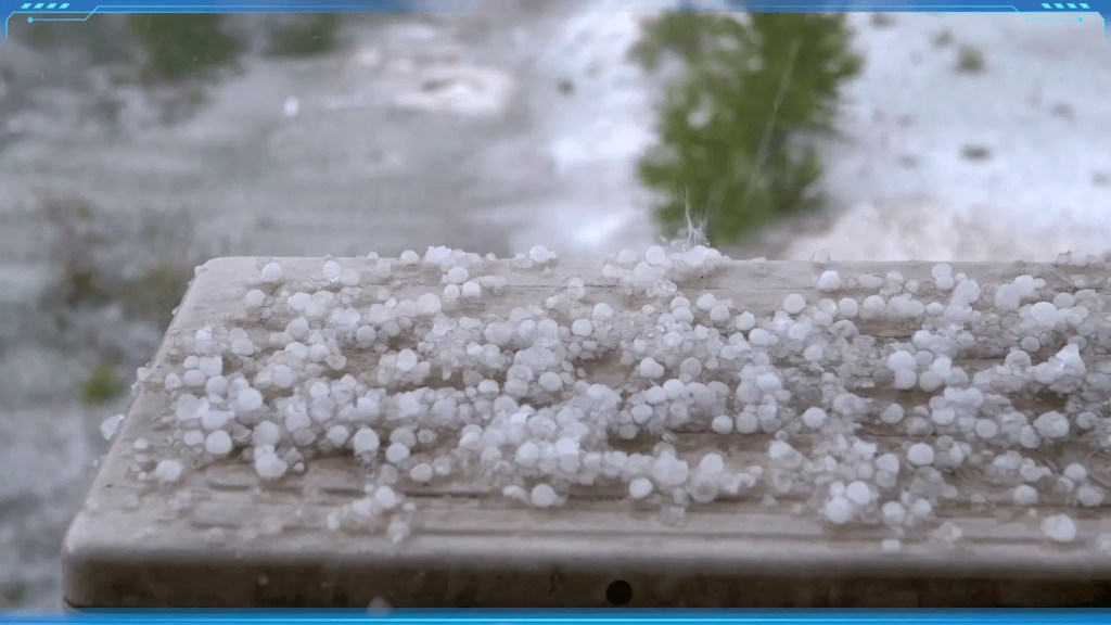 A collection of round ice chunks, or hailstones, on a wooden surface.